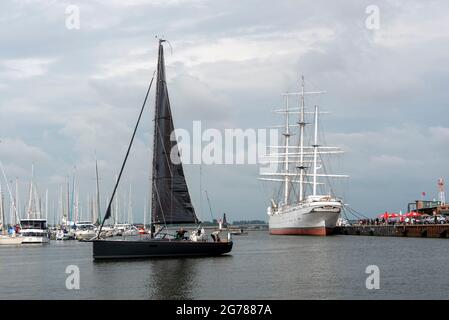 Stralsund, Germania. 23 Giugno 2021. Una barca a vela nera passa davanti al Gorch Fock 1 nel porto della città. Il tre-padrone serve come una nave del museo. Credit: Stefano Nosini/dpa-Zentralbild/ZB/dpa/Alamy Live News Foto Stock