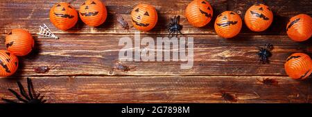 Halloween arancio ghirlanda sotto forma di zucca, ragni, scarafaggi su un vecchio tavolo di legno. Felice Halloween bello sfondo festivo. Spazio libero, banner spazio di copia Foto Stock