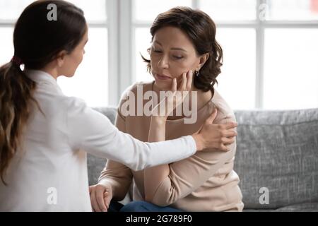 La figlia di grunnup di cura sostiene la madre matura sconvolta Foto Stock