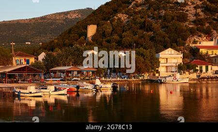 Isole IONIE, Ithaca, isola di Ulisse, Fries, alba, luce del mattino, umore del mattino, vista generale del porto, barche, edifici, colline con una torre di guardia sullo sfondo Foto Stock