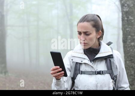 Perso temuto escursionista controllare la posizione gps su smartphone in natura Foto Stock