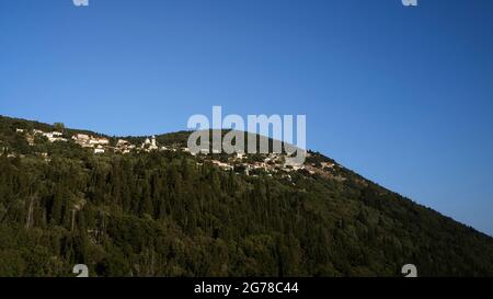 Isole IONIE, Ithaca, isola di Ulisse, villaggio di montagna Exogi, vista di tutto il villaggio, circondato da verdi foreste, cielo blu Foto Stock