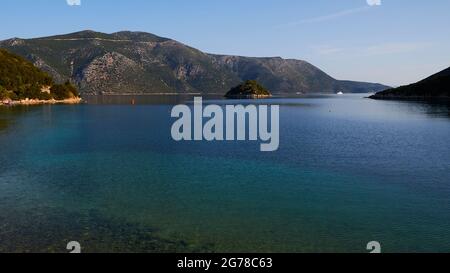 Isole IONIE, Ithaca, isola di Ulisse, capitale, Vathi, Vista della baia di Molos, mare turchese, verde e blu, vista dell'isolotto Skartsoubonisi, cielo blu, singole nuvole wispy Foto Stock