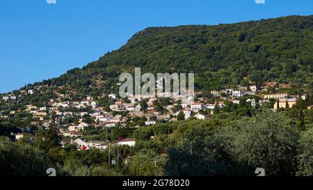 Isole IONIE, Ithaka, isola di Odysseus, Vathi, distretto di Perachori, si trova su una montagna boscosa, vista completa del luogo, boscosa montagna sul villaggio, cielo blu Foto Stock