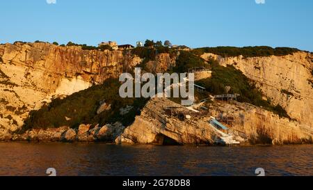 Isole IONIE, Zante, costa nord-orientale, Grotte Blu, Grotte Blu, la luce del mattino, la costa rocciosa, il palcoscenico di approdo delle barche, i gradini conducono alla costa, al mare scuro, al cielo blu reale Foto Stock