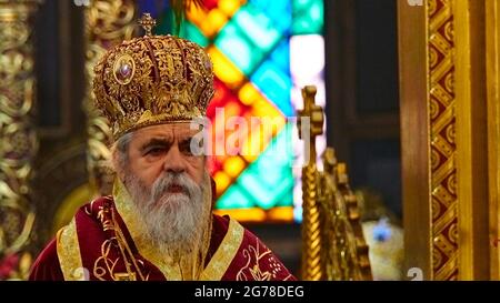 Isole IONIE, Zante, Zante, Chiesa di San Dionisio, Festa di San Dionisio il 17 dicembre, clergyman ortodosso in splendida canottiera rossa e corona si erge con scettro in mano e guarda i credenti, Foto Stock