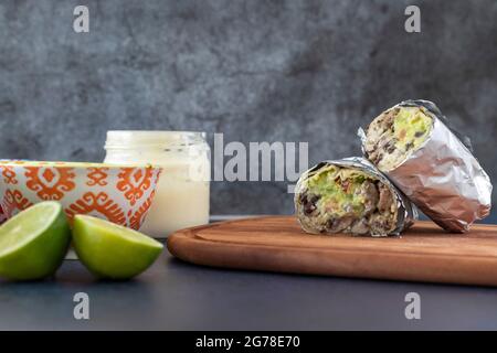 burrito messicano servito su un tavolo di legno. Foto Stock