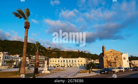 Zante, città di Zante, Piazza Solomos, palme a sinistra, Museo bizantino di Zante al centro, Chiesa di Agios Nikolaos Molos a destra, luce del mattino, cielo blu, nuvole grigio-bianche, grandangolo Foto Stock