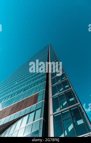 Madrid, Spagna - 7 febbraio 2021: Vista ad angolo basso del grattacielo nella zona commerciale di Cuatro Torres. Vista contro il cielo blu. Torre di Espacio. Business e. Foto Stock