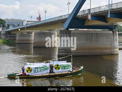 12 luglio 2021, Brandeburgo, Francoforte (Oder): I membri della Gioventù Verde di Brandeburgo e dei deputati Verdi polacchi protestano con striscioni in entrambe le lingue su una nave sul fiume Oder confine tedesco-polacco contro i progetti della Polonia per una nuova centrale nucleare. La nave salpò e scese lungo il fiume per circa un'ora tra le due città di confine di Francoforte (Oder) in Germania e Slubice in Polonia. Nel 2020, la Polonia ha deciso un programma nucleare con l'obiettivo di costruire sei centrali nucleari in Polonia entro il 2043, due delle quali sul Mar Baltico vicino a Danzica, a 450 km da Berlino. Il primo è essere costruito come Foto Stock