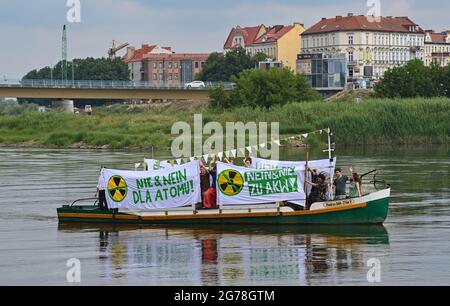 12 luglio 2021, Brandeburgo, Francoforte (Oder): I membri della Gioventù Verde di Brandeburgo e dei deputati Verdi polacchi protestano con striscioni in entrambe le lingue su una nave sul fiume Oder confine tedesco-polacco contro i progetti della Polonia per una nuova centrale nucleare. La nave salpò e scese lungo il fiume per circa un'ora tra le due città di confine di Francoforte (Oder) in Germania e Slubice in Polonia. Nel 2020, la Polonia ha deciso un programma nucleare con l'obiettivo di costruire sei centrali nucleari in Polonia entro il 2043, due delle quali sul Mar Baltico vicino a Danzica, a 450 km da Berlino. Il primo è essere costruito come Foto Stock