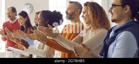 Un pubblico felice e diversificato applaudendo e ringraziando l'oratore o l'allenatore per una buona presentazione Foto Stock