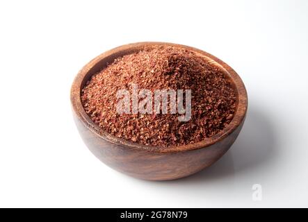 Polvere di sumac essiccato in bowl.on sfondo bianco Foto Stock