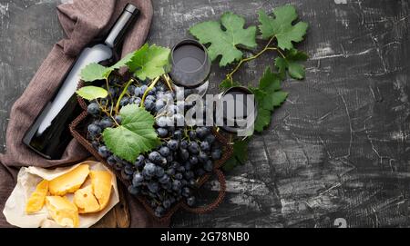 Bottiglia di vino rosso formaggi uva paio di bicchieri da vino. Composizione del vino d'annata ancora da vita con formaggio stagionato, uva. Cena al ristorante, degustazione di vini Foto Stock