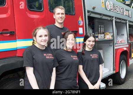 Drakes Pool, Cork, Irlanda. 12 luglio 2021. Chris Gledhill, responsabile della stazione dei vigili del fuoco di Carrigaline, e sua moglie Lesley-Anne con sua figlia Chloe e Kayla Cotter al loro motore di fuoco convertito, che ora opera come caffetteria presso il popolare servizio di piscina di Draks fuori Crosshaven, Co. Cork, Irlanda. - immagine; David Creedon / Alamy Live News Foto Stock