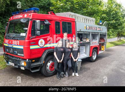 Drakes Pool, Cork, Irlanda. 12 luglio 2021. Chris Gledhill, responsabile della stazione dei vigili del fuoco di Carrigaline, e sua moglie Lesley-Anne con sua figlia Chloe e Kayla Cotter al loro motore di fuoco convertito, che ora opera come caffetteria presso il popolare servizio di piscina di Draks fuori Crosshaven, Co. Cork, Irlanda. - immagine; David Creedon / Alamy Live News Foto Stock