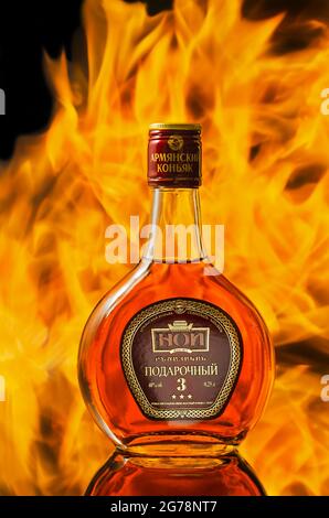 Una bottiglia di cognac armeno, fotografata sullo sfondo di una fiamma. Dimitrovgrad, Russia, 8 agosto 2018 Foto Stock