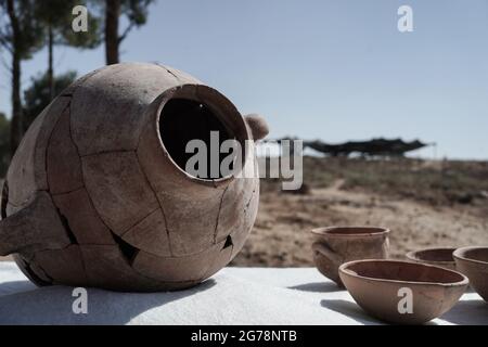 Khirbet un Rai, Israele. 12 luglio 2021. Manufatti esposti nel sito di Khirbet a Rai ai ai piedi della Giudei, precedentemente identificato come la città filistea biblica di Ziklag dai giorni del re Davide, Il luogo in cui Davide trovò rifugio mentre fuggiva dal re Saul e da qui andò a Hebron per essere unto come re. Un'iscrizione d'inchiostro senza precedenti di Proto Canaanite scritto su un vaso di ceramica scoperto porta il nome Jerubbaal, il nome del Giudice Gideon ben Yoash dal Libro dei Giudici. I risultati degli scavi condotti dall'Università Ebraica di Gerusalemme, l'Israele A. Foto Stock