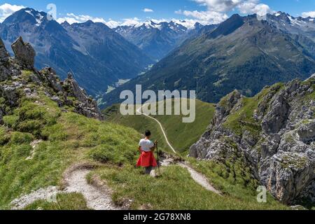 Europa, Austria, Tirolo, Alpi Stubai, escursionista femminile in discesa con vista su Habicht e Brennerspitze Foto Stock