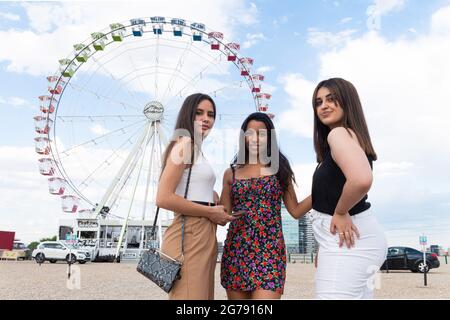 Ruota in ferro colorata in estate con tre amici felici Foto Stock