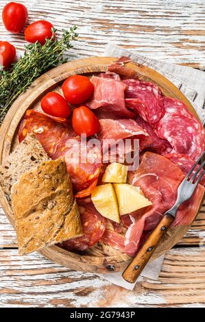 Piatto di carne fredda, salumi tradizionali tapas spagnole su tavola di legno. Sfondo bianco di legno. Vista dall'alto Foto Stock