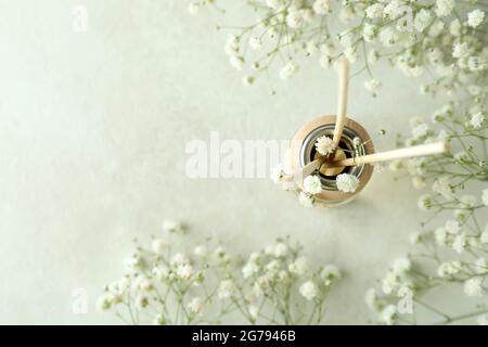 Diffusore e fiori su tavolo bianco testurizzato Foto Stock