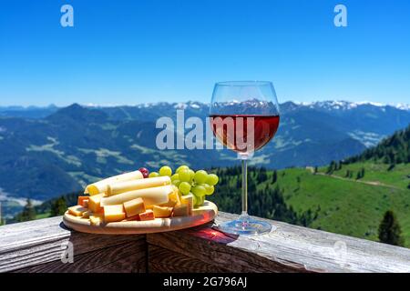 formaggio tirolo fresco con vino e uva sul paesaggio montano Foto Stock