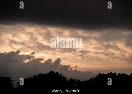 Drammatico cielo giallo nuvoloso prima della tempesta serale. Foto scattata in condizioni di scarsa illuminazione Foto Stock