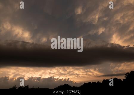 Drammatico cielo giallo nuvoloso prima della tempesta serale. Foto scattata in condizioni di scarsa illuminazione Foto Stock