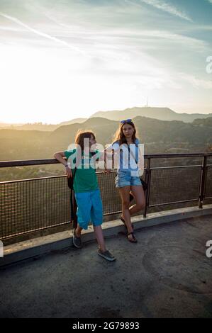 Una ragazza caucasica, 15-20 anni e ragazzo caucasico, 10-15 anni di fronte alle Hollywood Hills, Los Angeles, California, USA Foto Stock