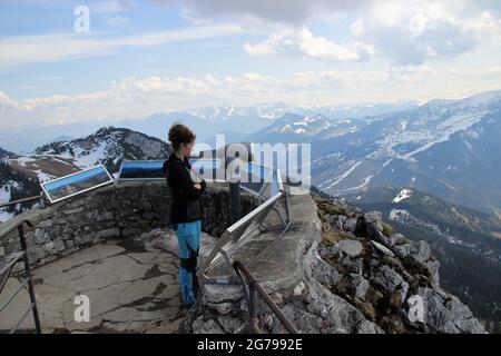 Giovane donna si trova al punto di vista di Wendelstein, Mangfall Mountains, Pre-Alpi, alta Baviera, Baviera, Germania Foto Stock