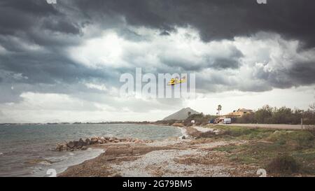 Aereo antincendio sul mare con un'atmosfera di tempesta Foto Stock