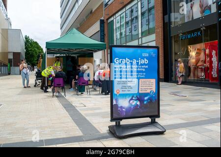 Bracknell, Berkshire, Regno Unito. 12 luglio 2021. Gli acquirenti del centro commerciale Lexicon di Bracknell sono stati in grado di afferrare-a-jab oggi solo per la loro prima vaccinazione Covid-19. I vaccini che venivano somministrati solo a più di 18 anni erano Pfizer. I volontari della Carità Arca di Ascot e del Servizio Volontario reale erano a disposizione per consigliare gli acquirenti. Il servizio fornito dal NHS e dal Bracknell Forest Council si è rivelato molto popolare. Credit: Maureen McLean/Alamy Live News Foto Stock