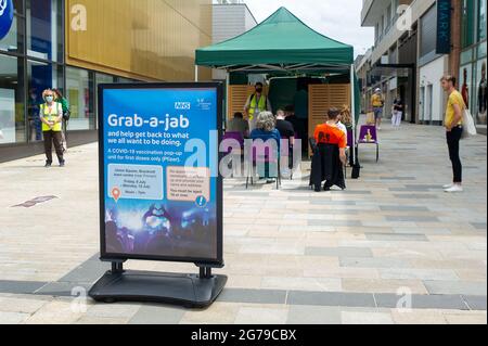 Bracknell, Berkshire, Regno Unito. 12 luglio 2021. Gli acquirenti del centro commerciale Lexicon di Bracknell sono stati in grado di afferrare-a-jab oggi solo per la loro prima vaccinazione Covid-19. I vaccini che venivano somministrati solo a più di 18 anni erano Pfizer. I volontari della Carità Arca di Ascot e del Servizio Volontario reale erano a disposizione per consigliare gli acquirenti. Il servizio fornito dal NHS e dal Bracknell Forest Council si è rivelato molto popolare. Credit: Maureen McLean/Alamy Live News Foto Stock