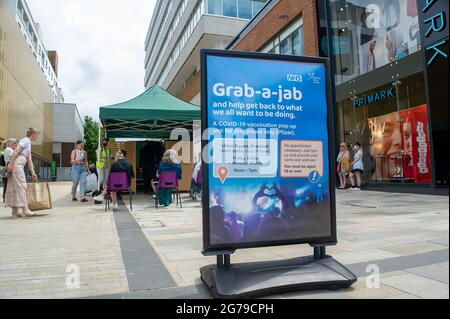 Bracknell, Berkshire, Regno Unito. 12 luglio 2021. Gli acquirenti del centro commerciale Lexicon di Bracknell sono stati in grado di afferrare-a-jab oggi solo per la loro prima vaccinazione Covid-19. I vaccini che venivano somministrati solo a più di 18 anni erano Pfizer. I volontari della Carità Arca di Ascot e del Servizio Volontario reale erano a disposizione per consigliare gli acquirenti. Il servizio fornito dal NHS e dal Bracknell Forest Council si è rivelato molto popolare. Credit: Maureen McLean/Alamy Live News Foto Stock