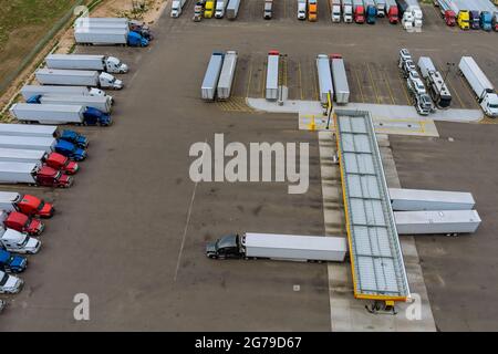 Posizione di riposo il camion ferma su vari tipi di camion in un parcheggio fuori autostrada con stazione di benzina per il rifornimento auto negli Stati Uniti Foto Stock