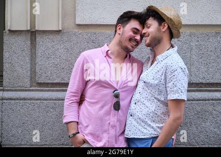 Giovane coppia gay sorridente e con un momento di affetto in strada. Foto Stock
