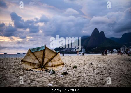 Ombrello rotto alla spiaggia di Ipanema con la montagna Dois Irmaos in background Foto Stock