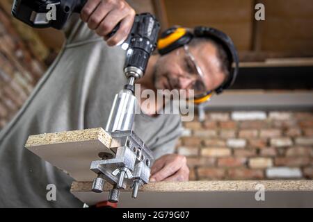 Falegname professionale che lavora con legno e utensili da costruzione in casa. Foto Stock
