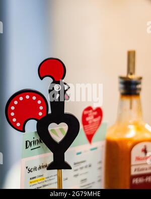 Bournemouth, Regno Unito. 6 novembre 2019. Il logo del ristorante Nando, il menu e la salsa peri si offuscavano sullo sfondo. Foto Stock