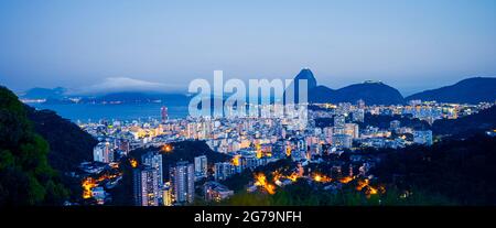 Vista panoramica al tramonto del Pan di zucchero (Morro pao de Açúcar) e Bahia de Guanabara con il quartiere Botafogo a Rio de Janeiro, Brasile Foto Stock