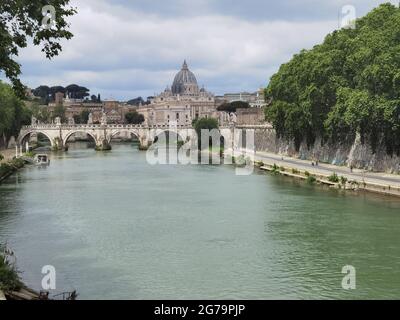 Ampia vista sul Tevere, a Roma, con i marciapiedi laterali e la vista, sullo sfondo, della cupola di San Pietro in Vaticano. Foto Stock