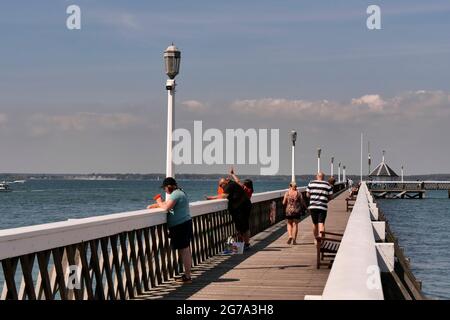 La gente pesca per i granchi dal molo di Yarmouth, il più lungo molo di legno in Inghilterra, Isola di Wight, Hampshire, Inghilterra, Regno Unito Foto Stock