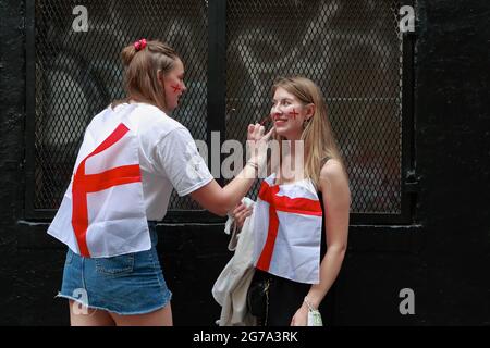 Londra (UK), 11 luglio 2021: Due tifosi inglesi Euro 2020 dipingono a vicenda i volti prima di fare la loro strada per guardare i versetti inglesi Foto Stock