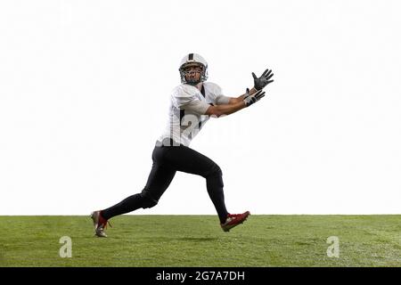 Calciatore americano in azione isolato su sfondo bianco studio. Concetto di sport professionale, campionato, competizione. Foto Stock