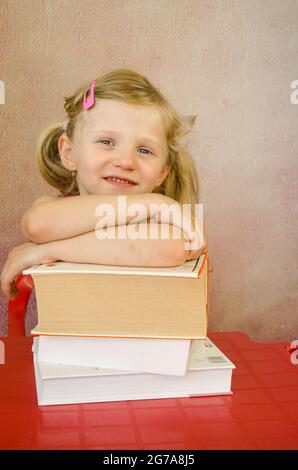 adorabile ragazza con mucchio di libri Foto Stock