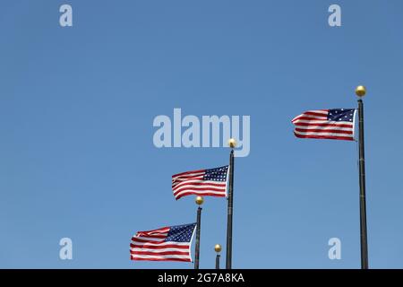 Stelle e strisce che volano contro un cielo blu USA Stati Uniti d'America bandiere Foto Stock