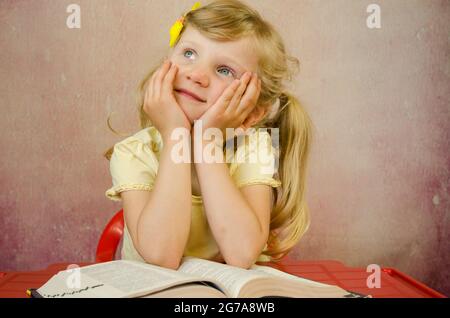 bella ragazza bionda su libro aperto Foto Stock