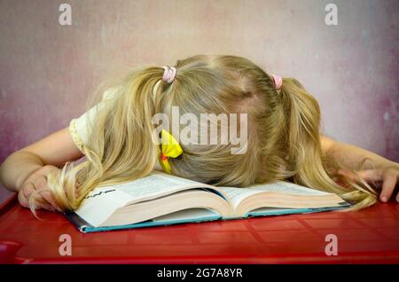 ragazza bionda che dorme su libro aperto Foto Stock