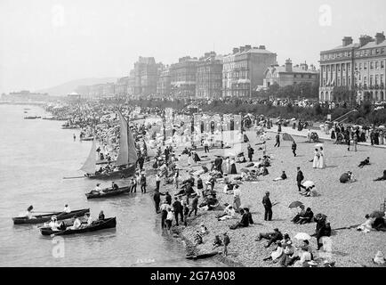 Fotografia d'epoca intitolata dal molo - Eastbourne, Sussex. Gli amanti della spiaggia dei primi anni del 1900 si vestirono per l'occasione come era il caso di allora. Foto Stock